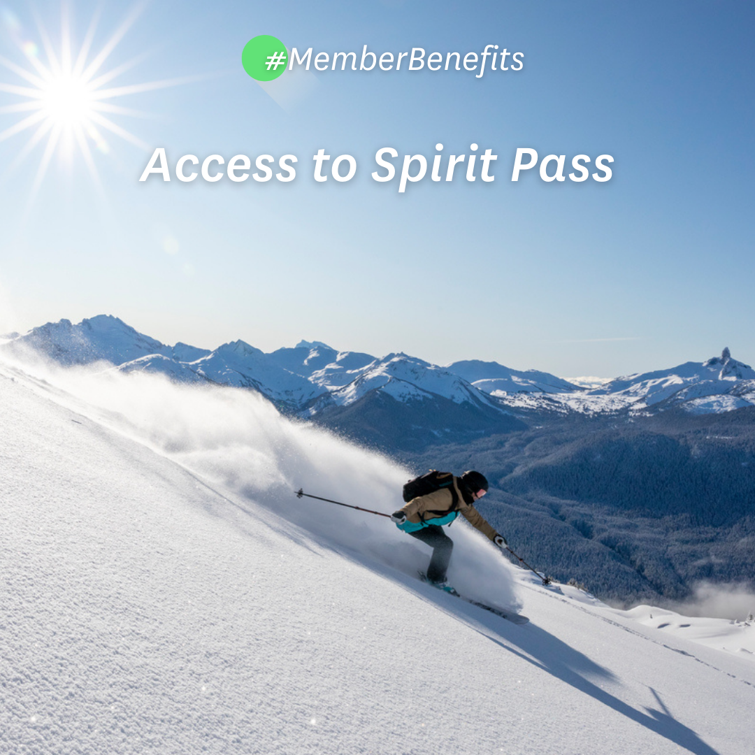 Access to Spirit Pass Skier riding down mountain on a sunny day blue skies and fresh powder kicking up behind