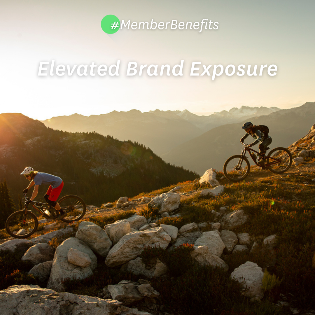 Two people biking down a rocky landscape in sunset