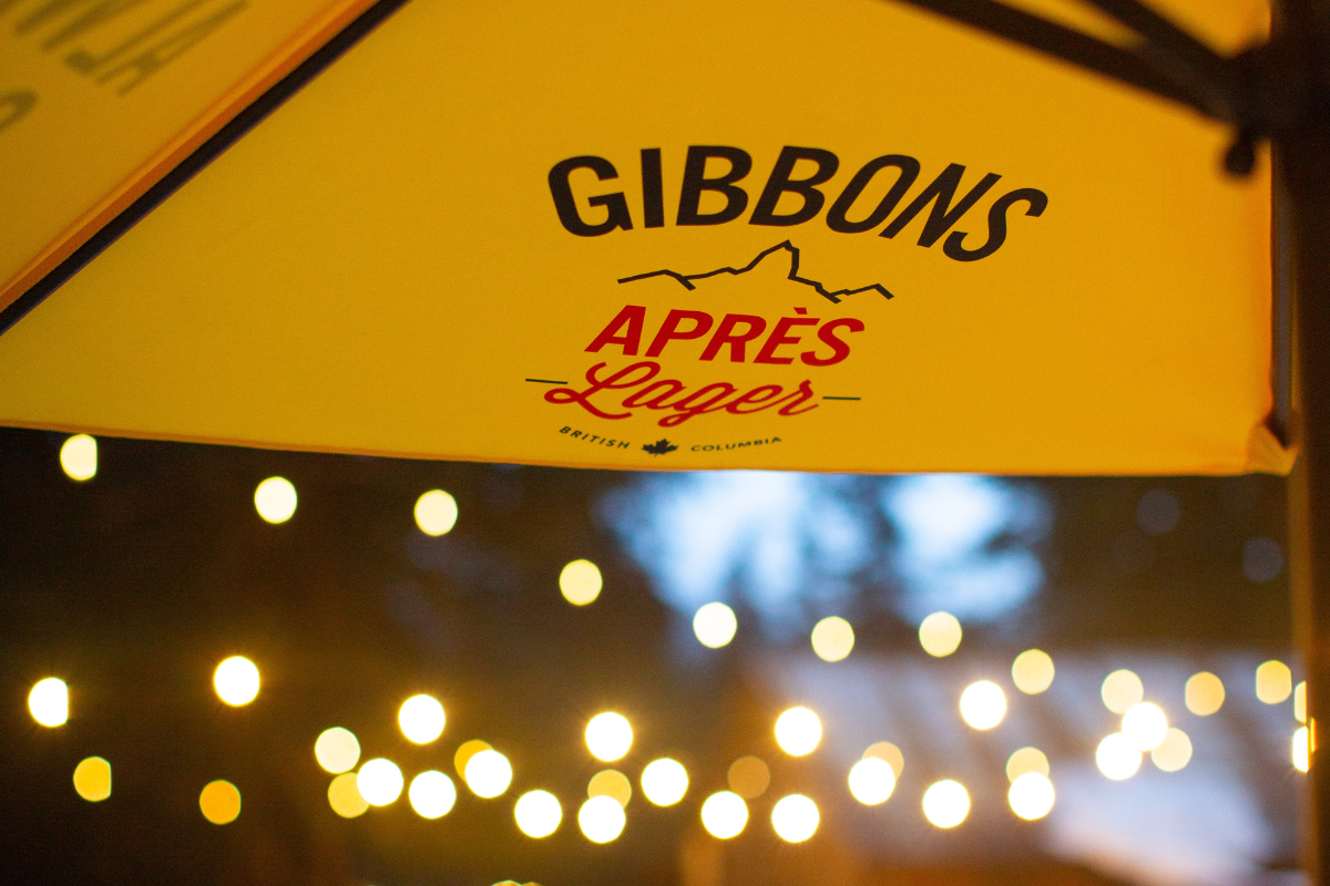 Skier riding down mountain on a sunny day blue skies and fresh powder kicking up behind
