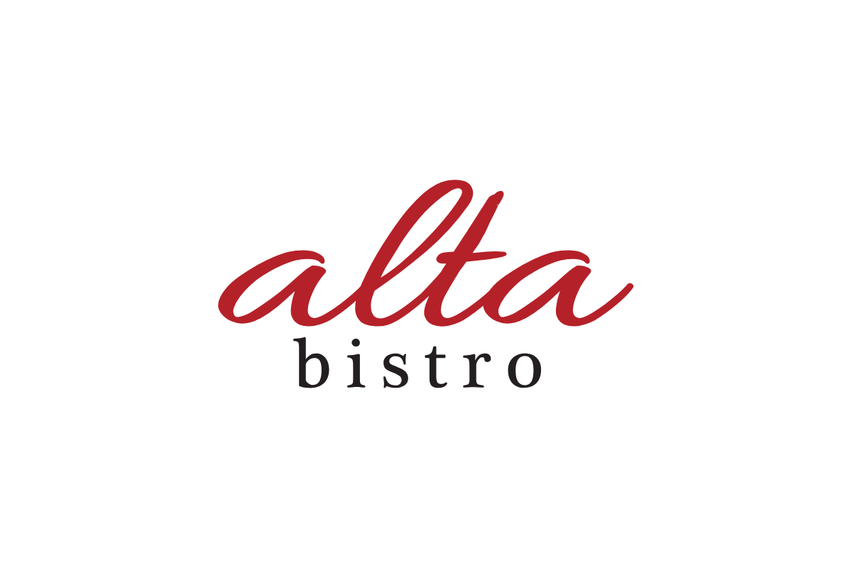 Skier riding down mountain on a sunny day blue skies and fresh powder kicking up behind