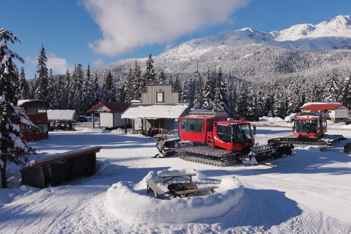 Skier riding down mountain on a sunny day blue skies and fresh powder kicking up behind