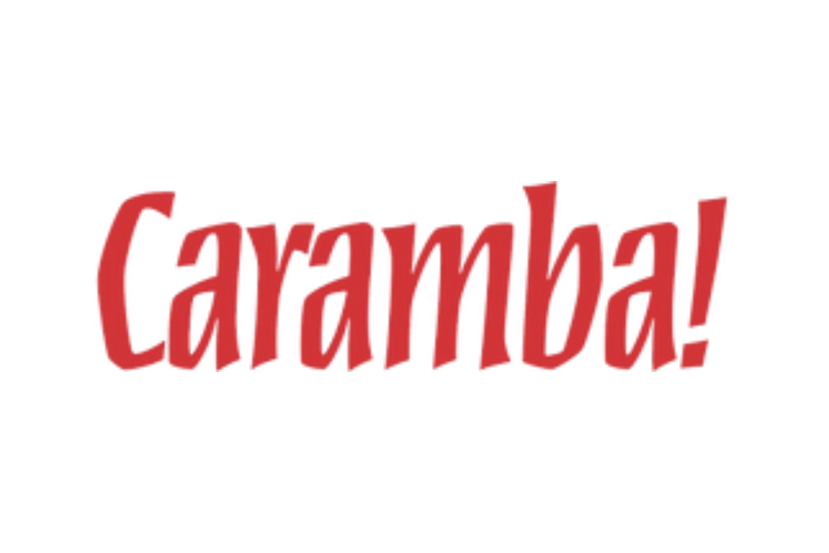 Skier riding down mountain on a sunny day blue skies and fresh powder kicking up behind