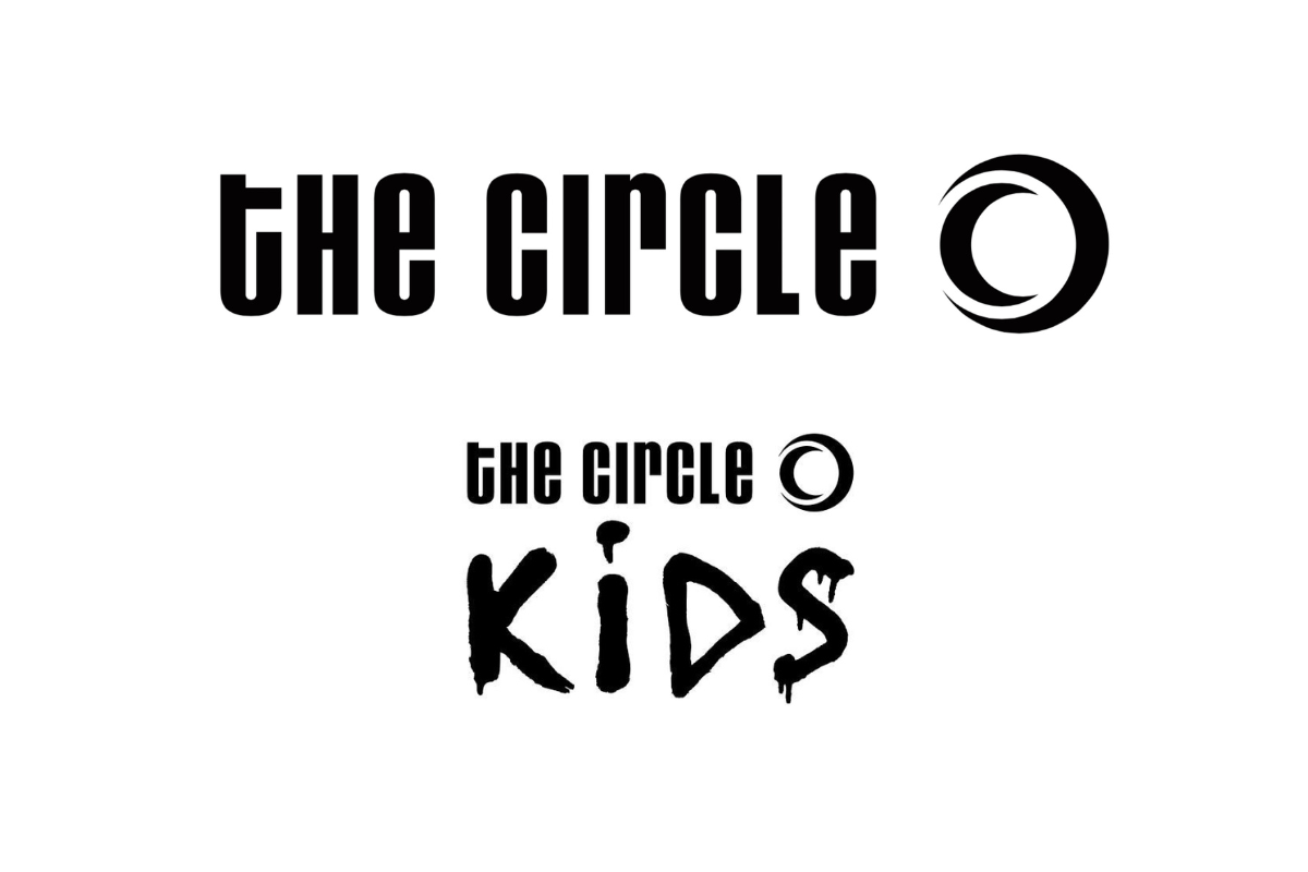 Skier riding down mountain on a sunny day blue skies and fresh powder kicking up behind