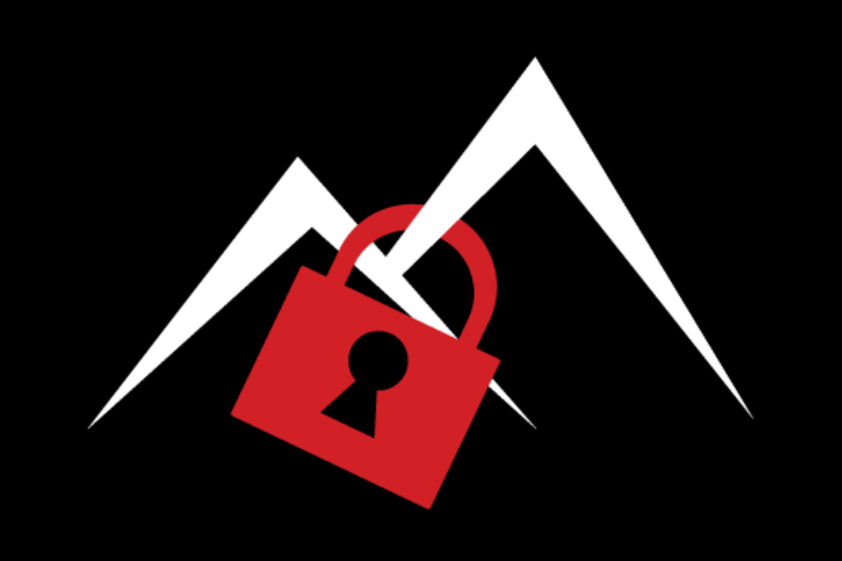 Skier riding down mountain on a sunny day blue skies and fresh powder kicking up behind