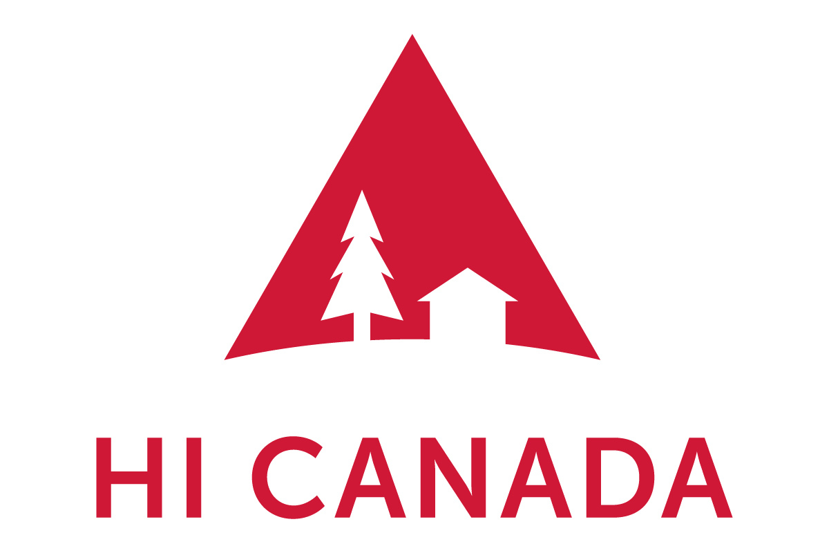 Skier riding down mountain on a sunny day blue skies and fresh powder kicking up behind