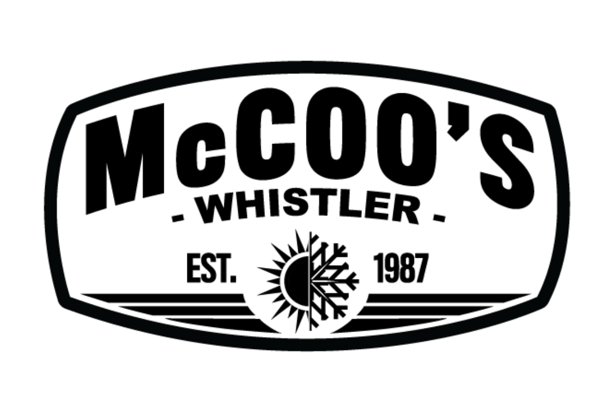 Skier riding down mountain on a sunny day blue skies and fresh powder kicking up behind