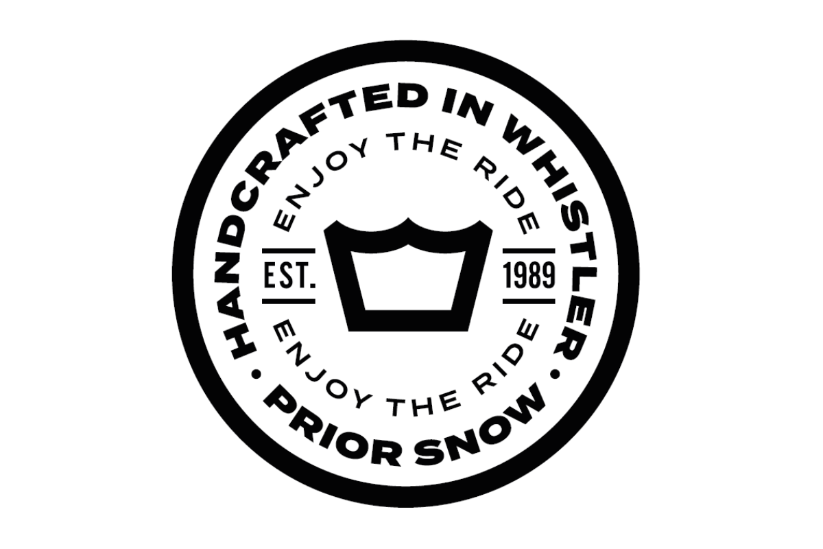 Skier riding down mountain on a sunny day blue skies and fresh powder kicking up behind