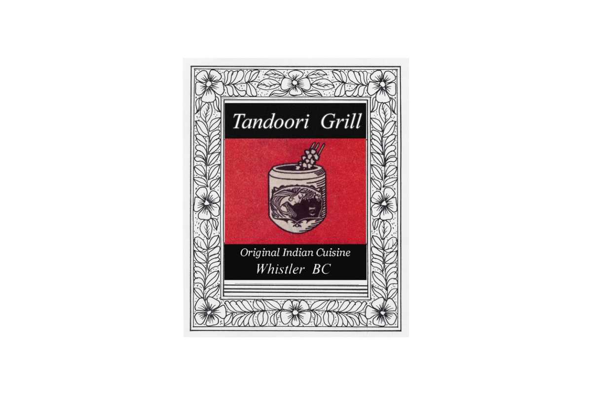 Skier riding down mountain on a sunny day blue skies and fresh powder kicking up behind