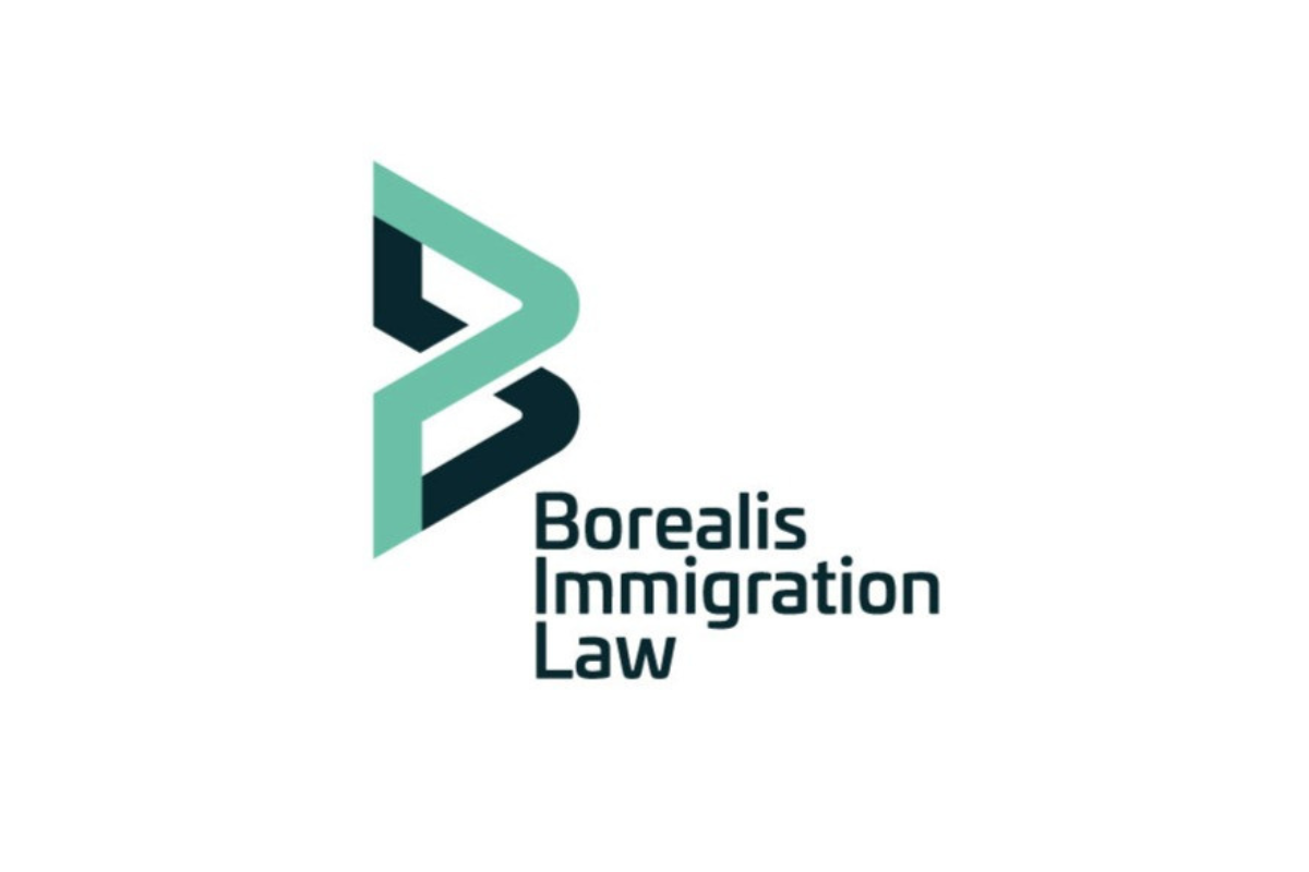 Skier riding down mountain on a sunny day blue skies and fresh powder kicking up behind