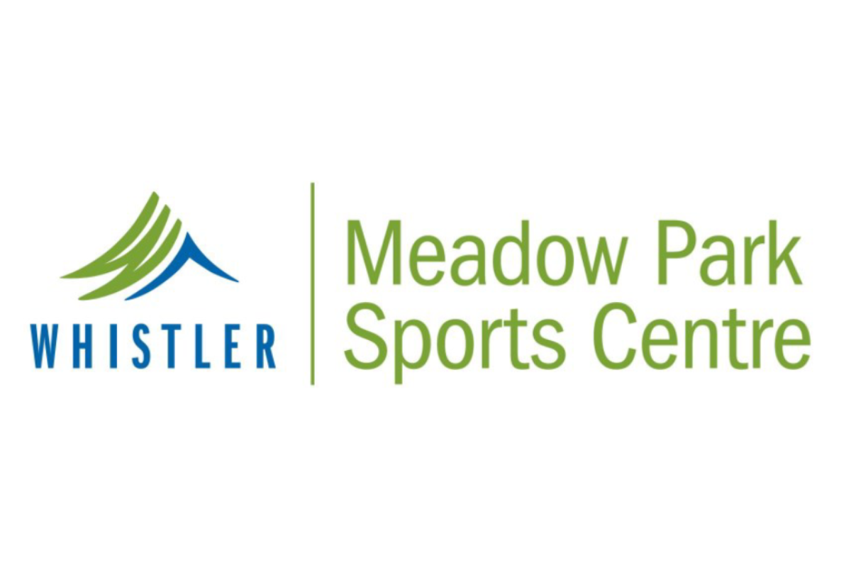 Skier riding down mountain on a sunny day blue skies and fresh powder kicking up behind