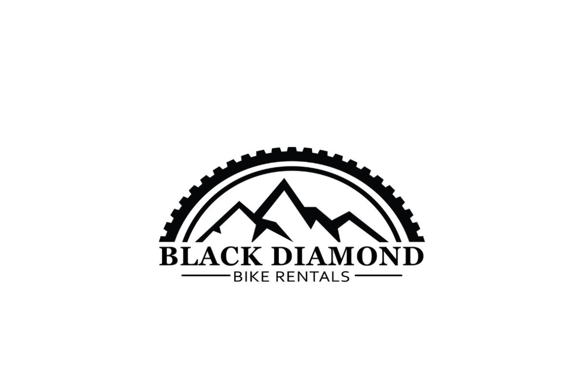 Black Diamond Bike Rental Skier riding down mountain on a sunny day blue skies and fresh powder kicking up behind